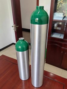 2 pc aluminium gas cylinder standing beside each other shiny body and green neck lacquered surface